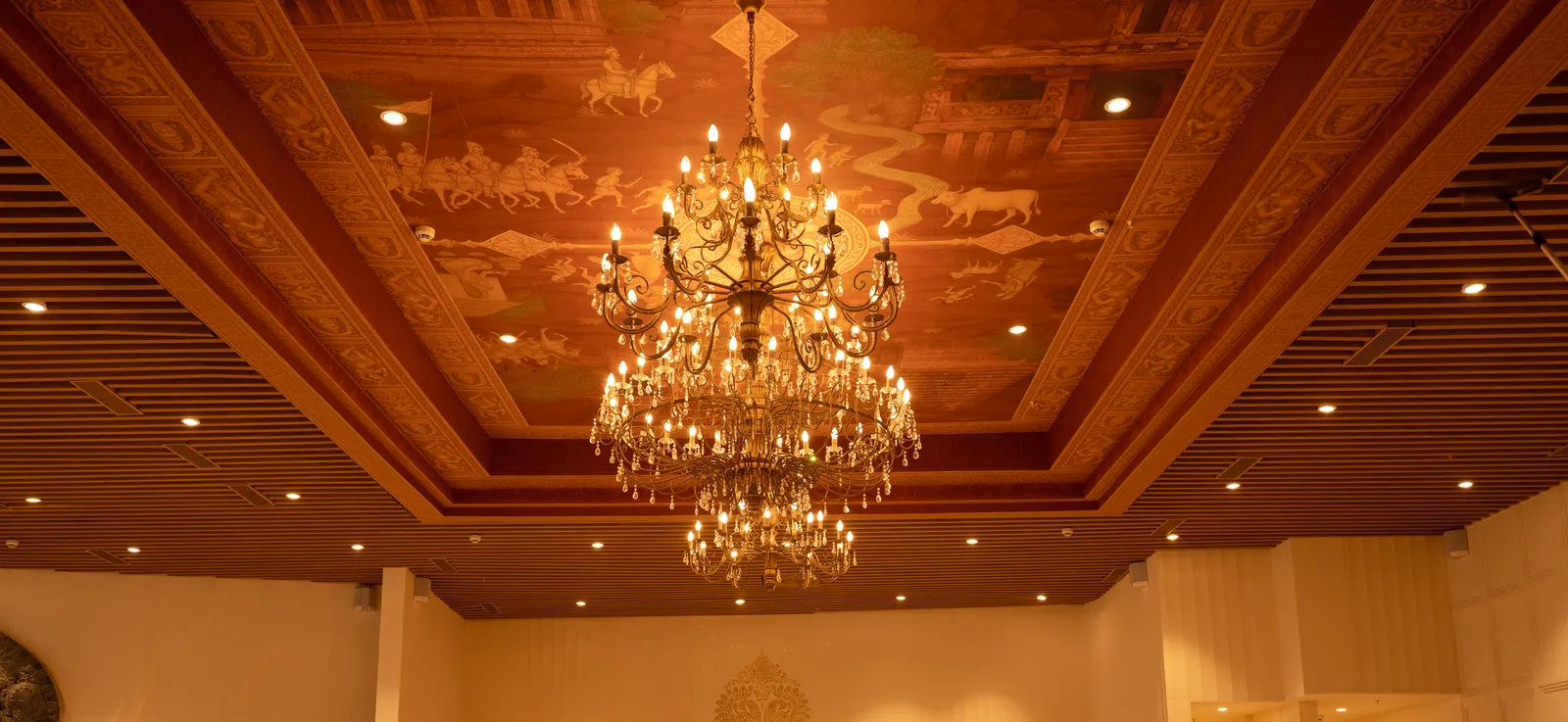 Banquet hall with crystal chandelier and painted wooden ceiling — Chalukya Samrat